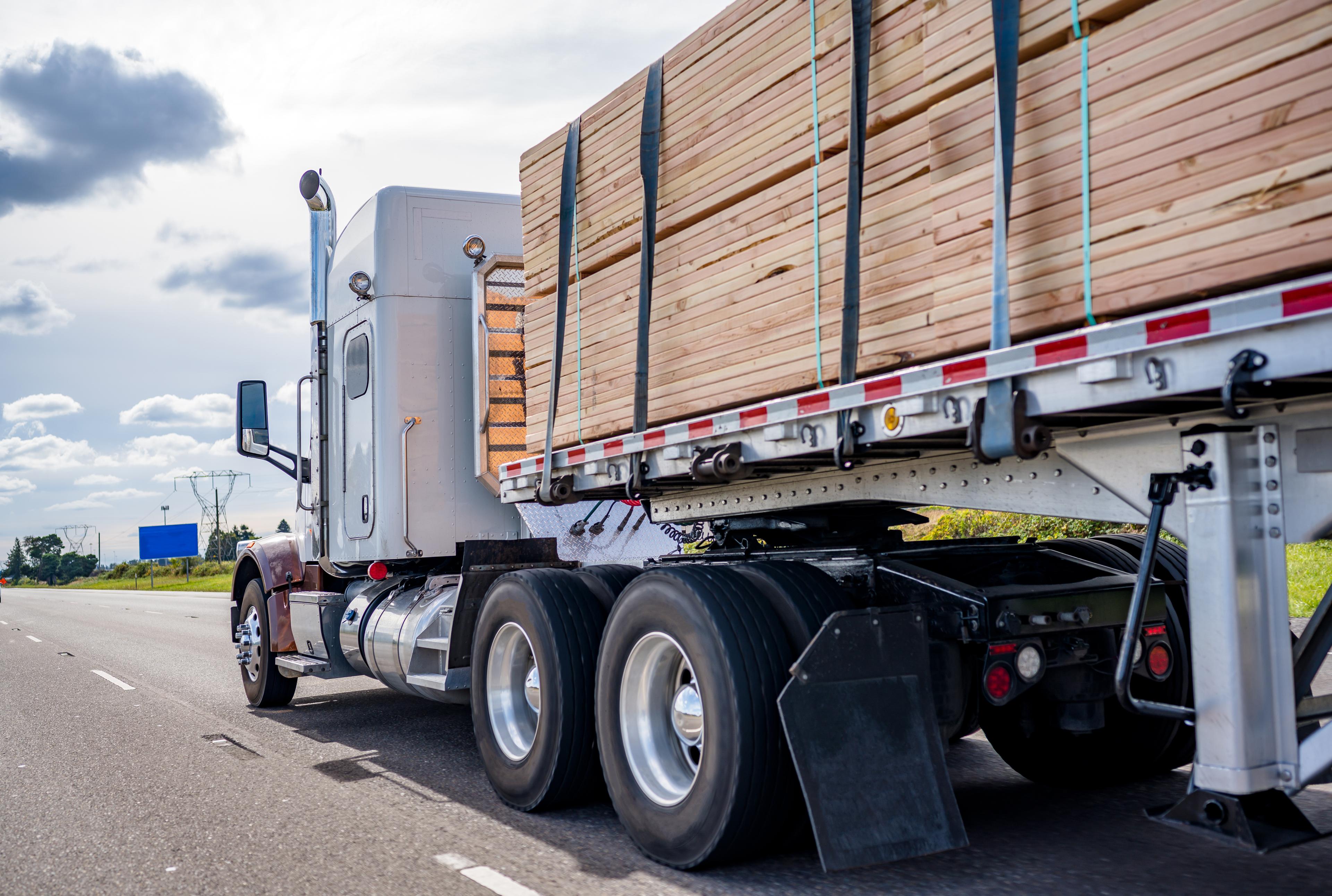 Aerial view of a semi-truck carrying lumber on a highway